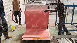 Workers are manually stripping a cathode copper sheet from the cathode plate