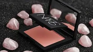 NARS Orgasm Blush on volcanic sand surrounded by rose quartz crystals