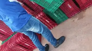 Empregado do Supermercado Primor, em Samambaia-DF, empilha caixotes de pl&aacute;sticos na cal&ccedil;ada.