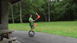 Juggling clubs while idling on a unicycle