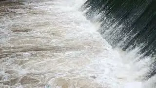 The Foam Of A Murky River Waterfall With The Original Sound Of A Waterfall