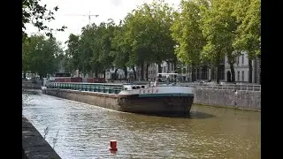 The navigator steers the barge with his head out of the porthole.