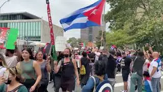 Free Afghanistan protesters march by a small group of Free Cuba protesters outside the UN