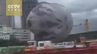 Bad moon rising as typhoon sets giant lunar inflatable bouncing around city