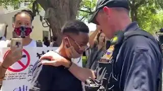 Police Officer Comforts Crying Protester
