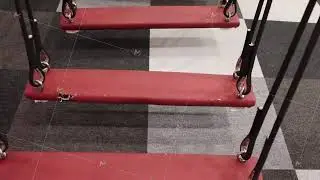 A closeup view of a red swing set situated on modern, stylish flooring surfaces