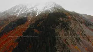 Aerial drone landscape of Mestia cliffs covered by small mist and creek flowing below