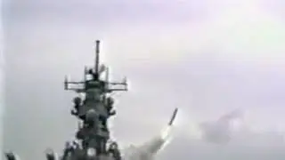 Iowa-class battleship firing 16 inch (406mm) guns and launching a tomahawk cruise missile.