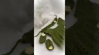 handmade crochet green dress with cream-colored flower embellishments on the bodice and straps