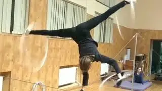 Girl Hula Hoops While Standing Upside Down on Thin Rope - 989678