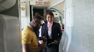 VideoVault Stock Video: Stewardess explains to a passenger where his seat is on the plane