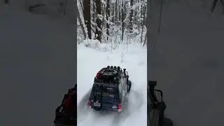 RC crawler tackling snowy forest trail