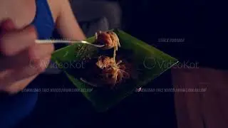 Macro view of man twirling spaghetti on the fork in the plate in his hand filmed in slow motion