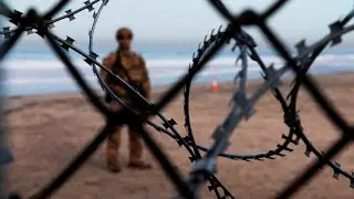Migrants crossing the US border facing large buoys and razor wire