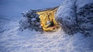 Solo shelter in winter storm .Building a stone survival shelter with fireplace between rocks
