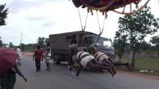 Men bouncing in Sri Lanka: suspended from tractor by hooks in your back