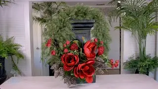 Christmas door wreath of red roses, lilies, magnolia, holly berries and a winter pine cones