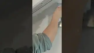 A person smooths wet wall plaster using a wide metal trowel tool #construction #popular