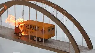 Toy truck is on fire. Cardboard bridge burns and collapses