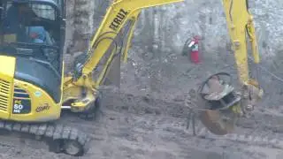 Komatsu PC50 excavator picking up hammer
