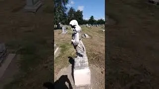 sculpture with old fashioned clothes in cemetery