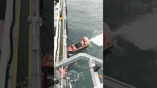 FAST RESCUE BOAT MANEUVERING AND APPROACHING ALONG SIDE OF SHIP, ITS A MAN OVERBOARD DRILL.