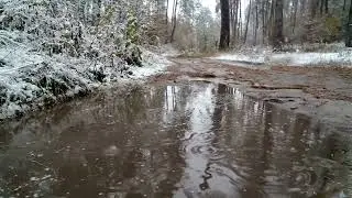 Rain drops on the surface of the water, rainwater stagnates in the snowy forest
