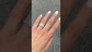 Round engagement ring in a cushion halo and matching wedding band