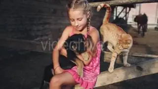 Curly Girl Caresses a Puppy and Cat at the Farm