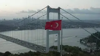 Turkish Flag Waving in Wind in front of Istanbul Bosphorus Bridge, Aerial medium shot slide right