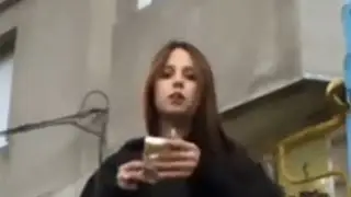 A Moldovan girl smokes a cigarette near the entrance to her building and throws trash on the floor