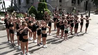 Las pequeñas gimnastas realizan un pasacalles para promocionar la escuela