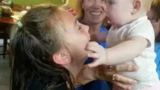 Baby eating her sisters face!