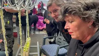 Burgemeester Rian van Dam helpt handje mee bij de Bloemencorso in Winkel