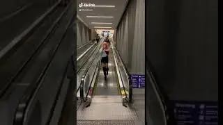 Girl Falls While Walking Off Airport Escalator - 1113512