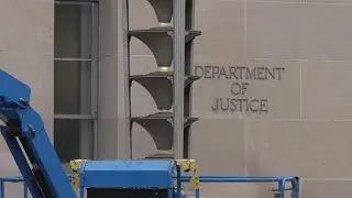 Large banner of Donald Trump hangs outside Justice Department in Washington, DC