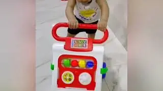 Baby learning to walk using walker for the first time