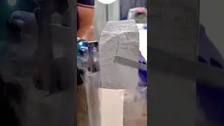 Worker cutting thick concrete block using electric circular saw
