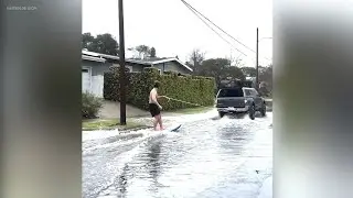 Man seen surfing through Long Beach streets during heavy flooding