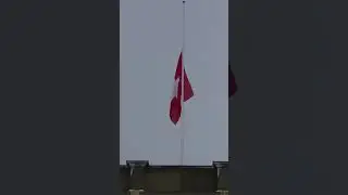 Zurich university building with Swiss flag waving on half mast because of fire disaster.
