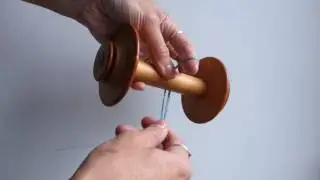Attaching a leader to a spinning wheel bobbin.