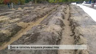 Процесс подготовки дренажной системы на поле с искусственной  травой