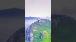 Man walking on rope between two high mountains