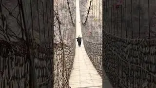 Monkey chases two men on suspension bridge during challenge in Henan, China