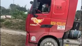 The tractor-trailer got stuck in the mud before entering the unloading area. 