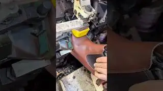 shoemaker uses a heavy industrial machine to shape and press a leather boot
