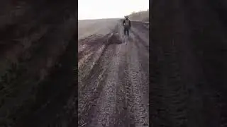 A soldier walking along an optical fiber cable from drones scattered across the front line