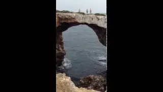 Cliff jumping from arch in Cala Varques Mallorca