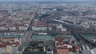 Aerial panorama revealing Lyon's urban tapestry, Saone river winding through cityscape, train