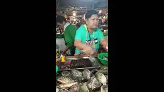 Philippines live fish seller cutting tilapia with much happiness & smile on face